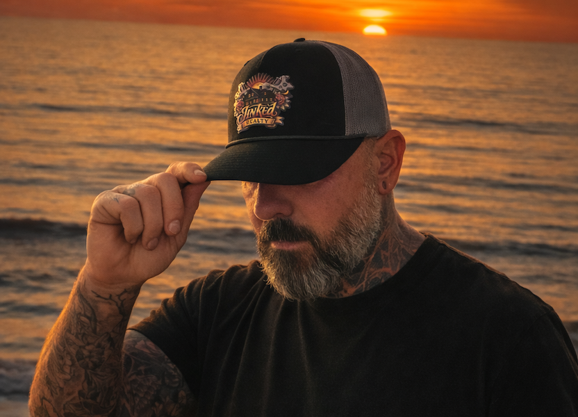 Man wearing a custom-made cap with a sunset over water in the background